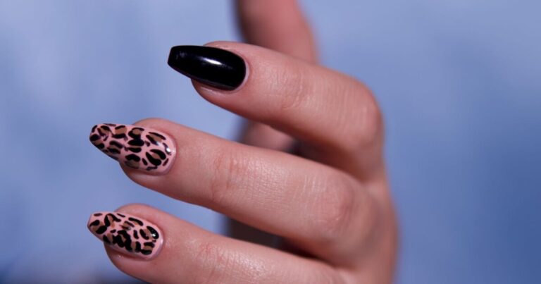 Long coffin nails in glossy black with leopard print accent nails, a classic autumn look