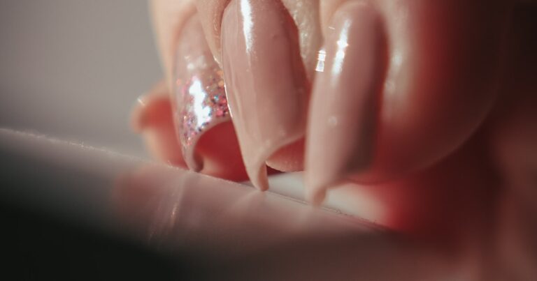 Birthday nails with glitter embellishments shown on a hand