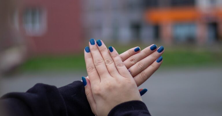 Blue nails with a glossy finish displayed on a hand