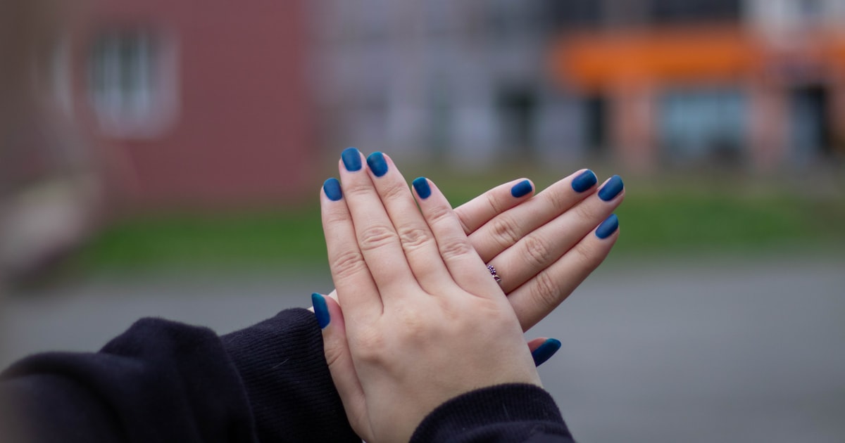 Blue nails with a glossy finish displayed on a hand