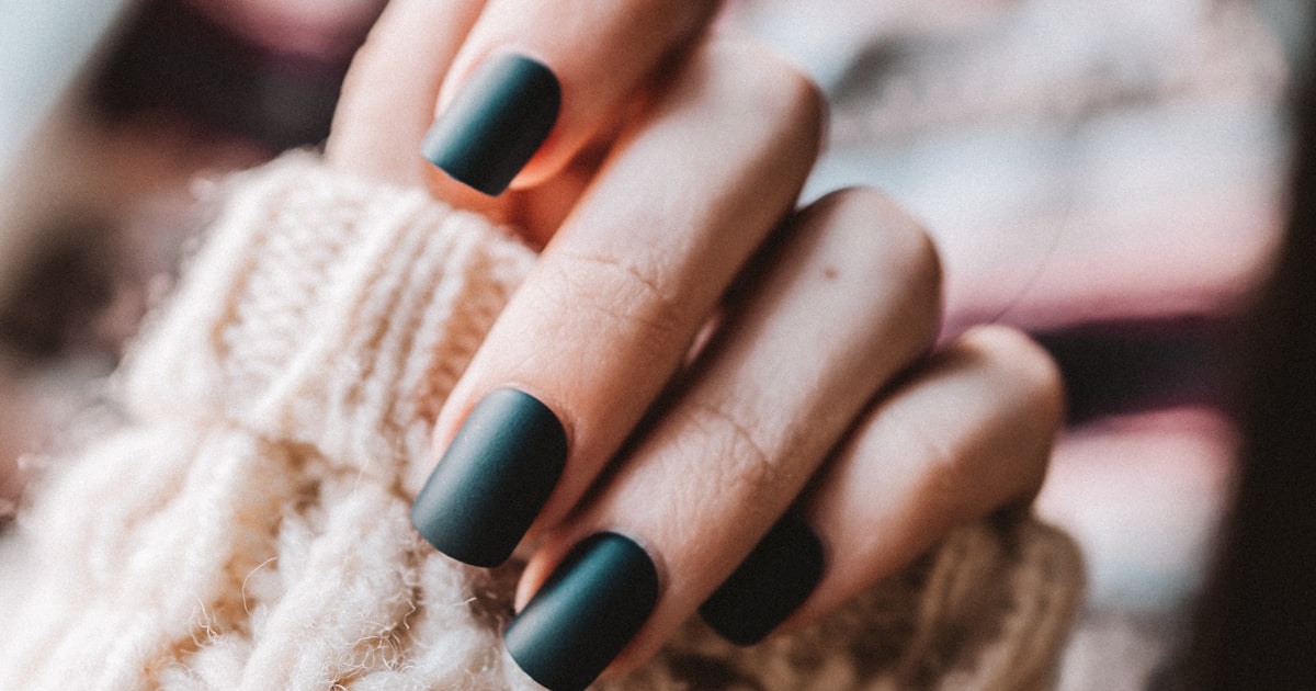 Midnight cat eye nails on a dark manicure against white fabric