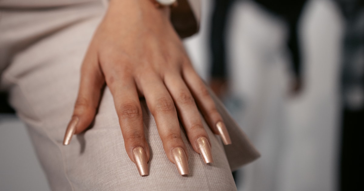 Gold chrome nails styled with a watch, a warm-undertone pairing