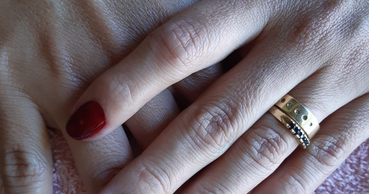 Diamond nails in red and gold with gem accents on a bold manicure