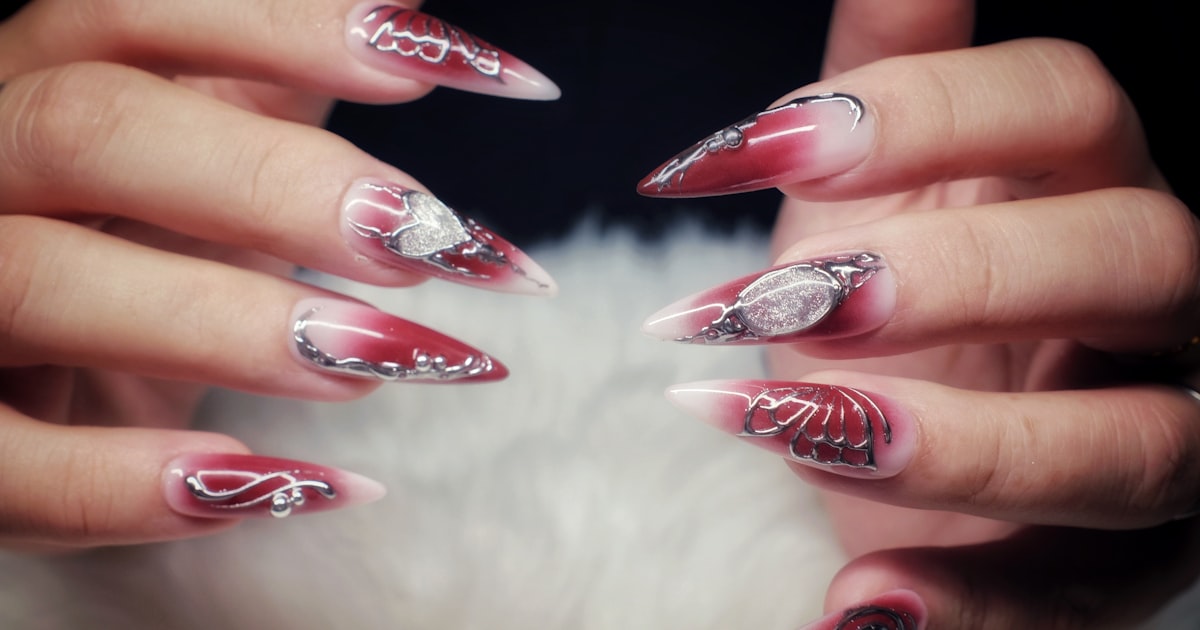 Lipstick nails 2026: long red manicure with a diagonal, angled tip