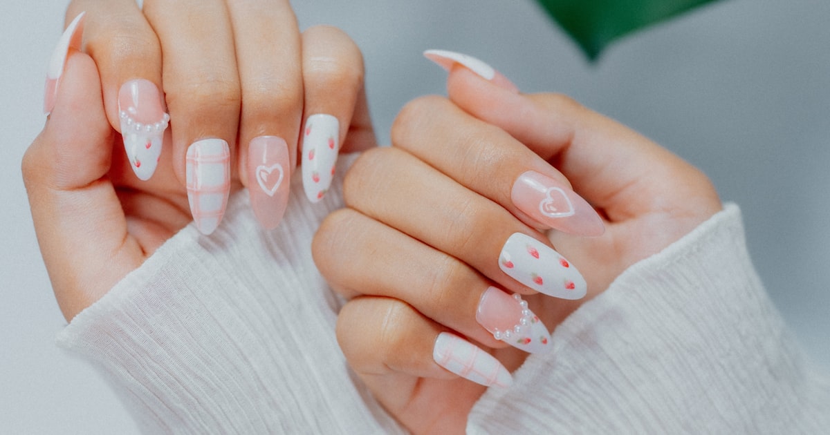Nail stamping plates creating a white and pink heart-motif design