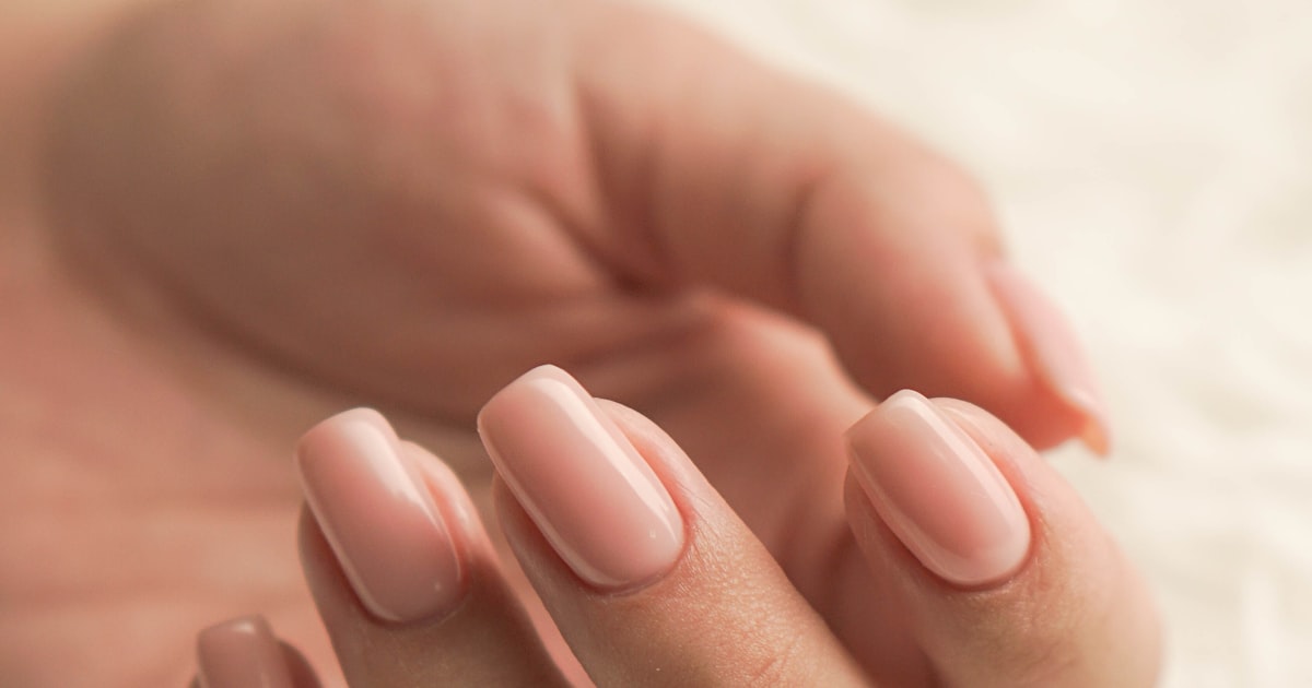 Short oval manicure with sheer pink polish, filed and glazed at home