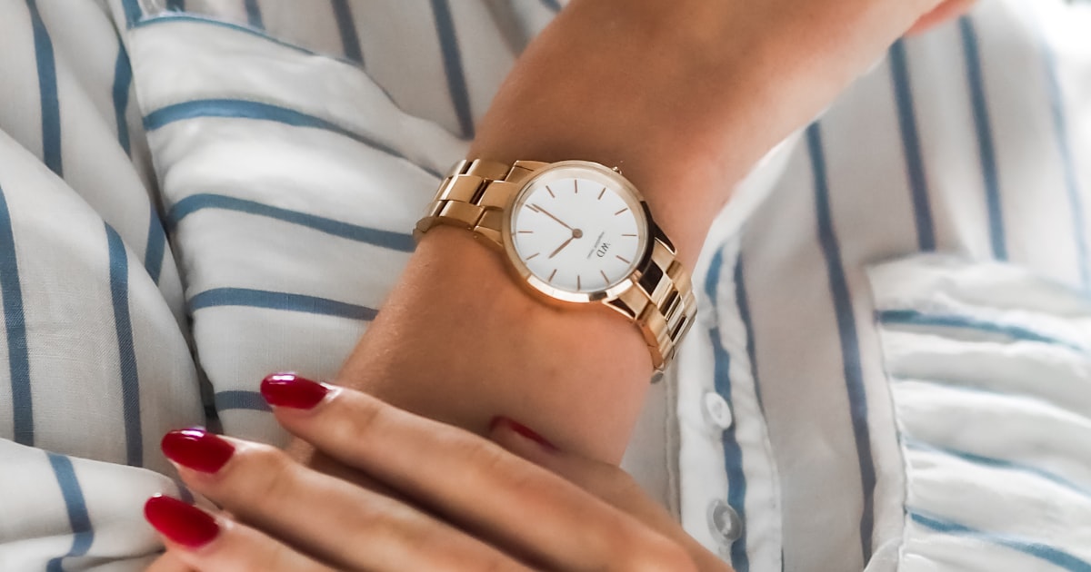 Red nails styled with a watch and gold jewelry