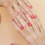 Hands with coordinating shades of semi-cured gel nail strips applied