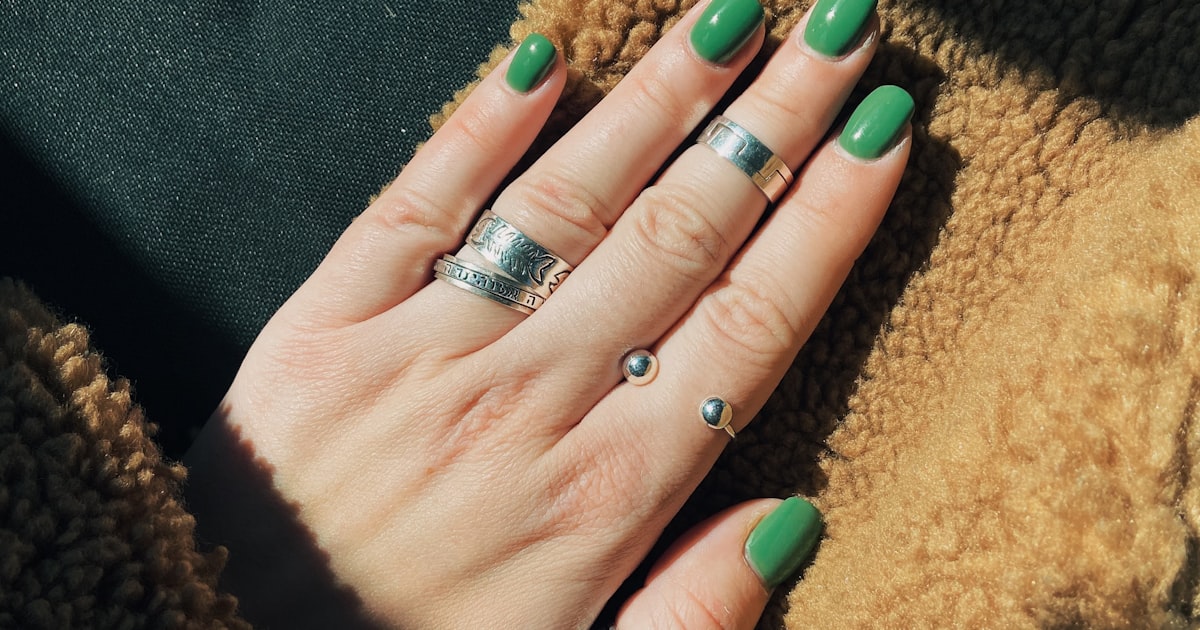 Square round nails with a glossy green manicure, showing the flat tip and softened corners
