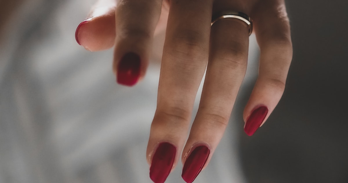 Neutral medium-length stiletto nails with minimal jewelry styling