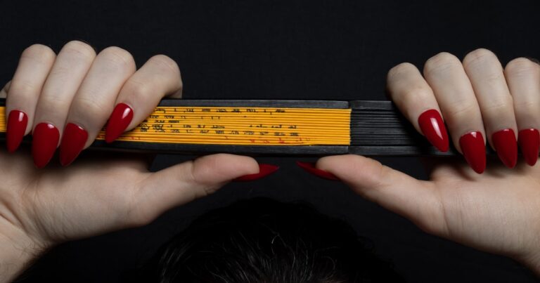 Stiletto nails in bold red, filed to a sharp point