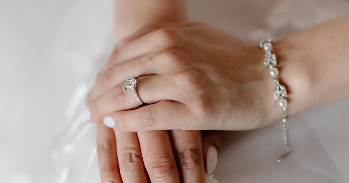 Bride displaying wedding nails alongside ring and bracelet