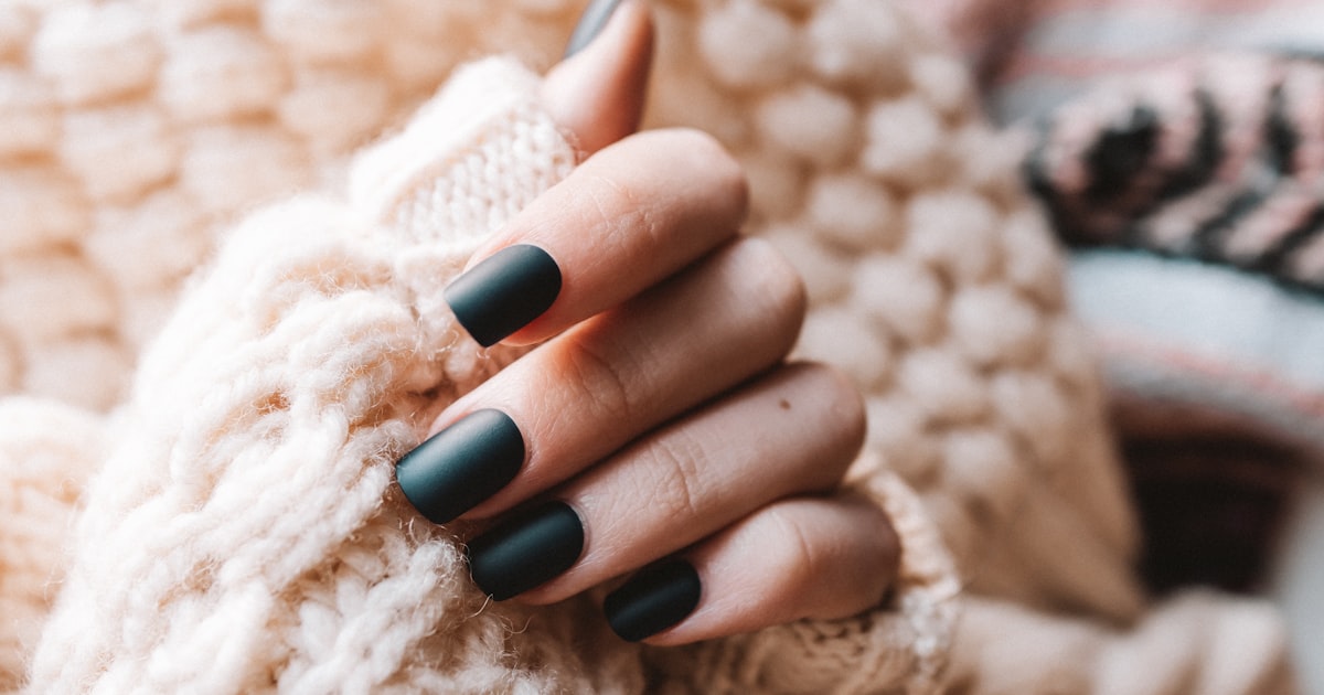 Winter nail colors at home: soft neutral manicure with a cozy white knit sweater