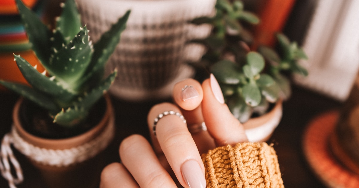 Natural ballerina nail shape shown holding a woven basket
