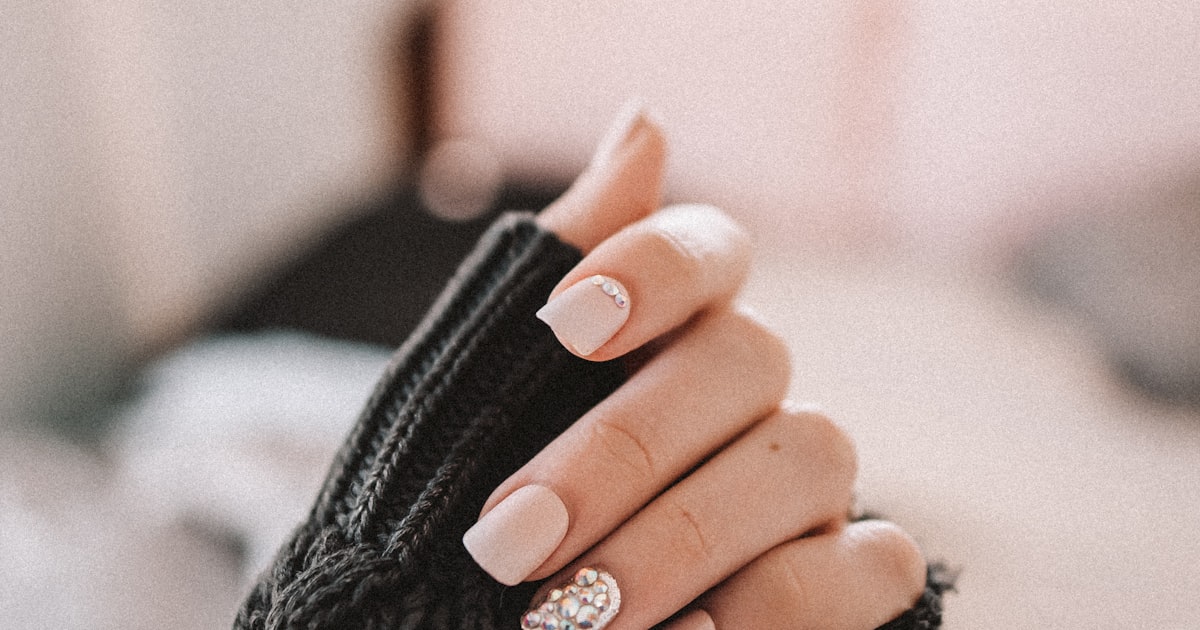 Neutral ballerina nail set styled with a black sleeve