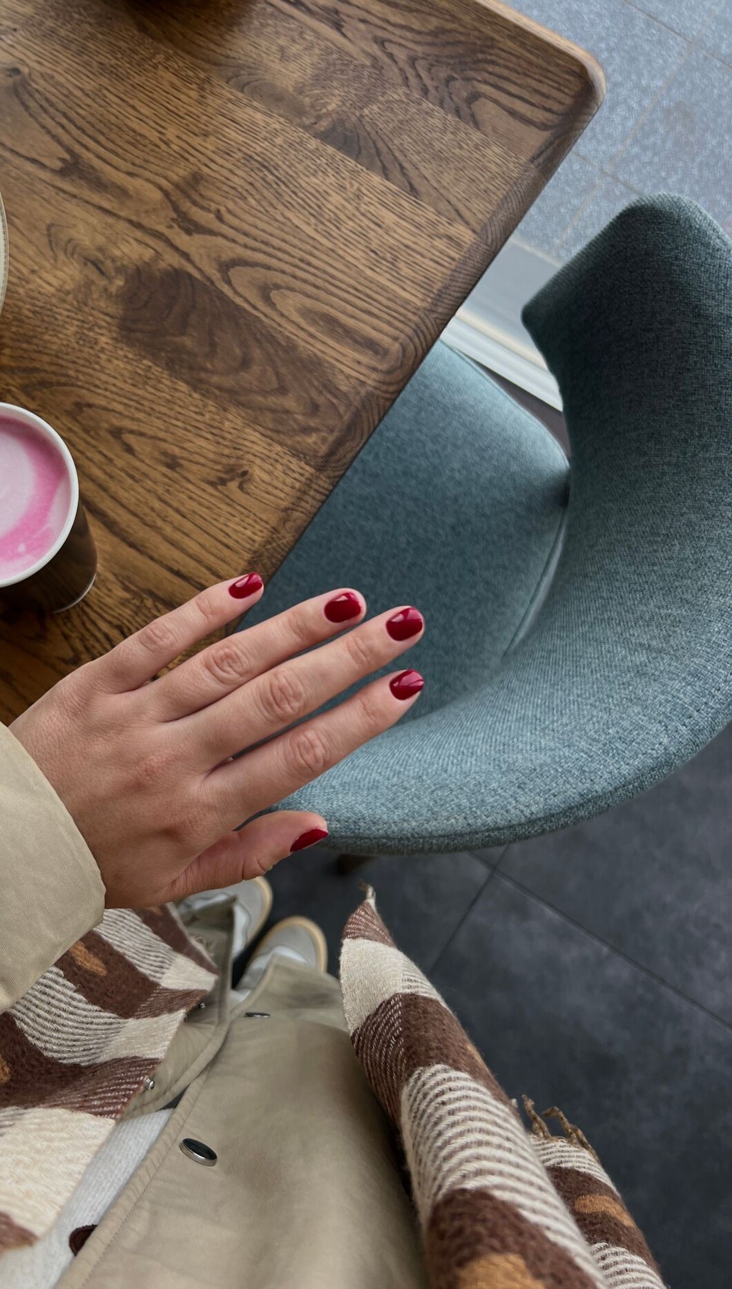 Short cherry red nails with a latte and brown plaid scarf for the summer to fall transition