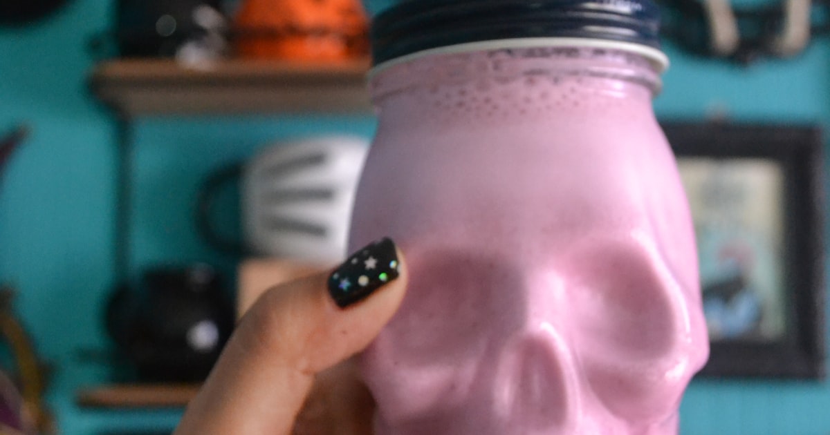 Halloween nails 2026 shown holding a pink glass jar