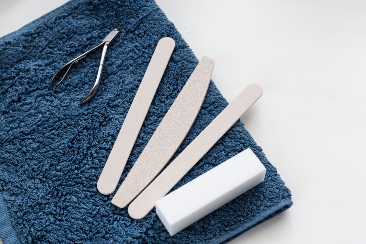 Nail care toolkit with cuticle stick and files used alongside a nail glue remover