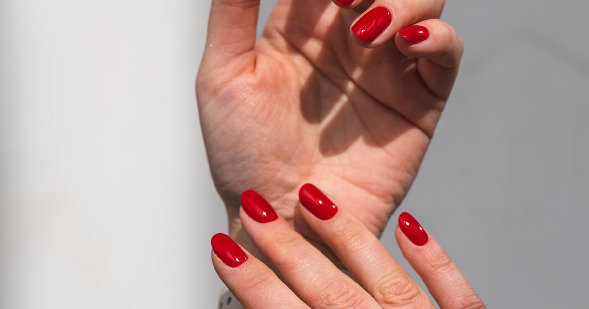 Glossy red semi-cured gel nail strips finish on hands