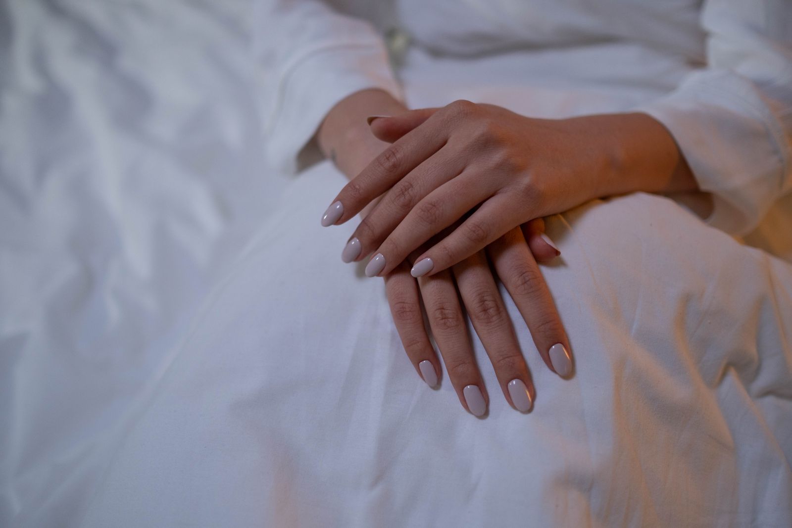 Office-ready September nails 2026: short sheer nude manicure on pale fabric