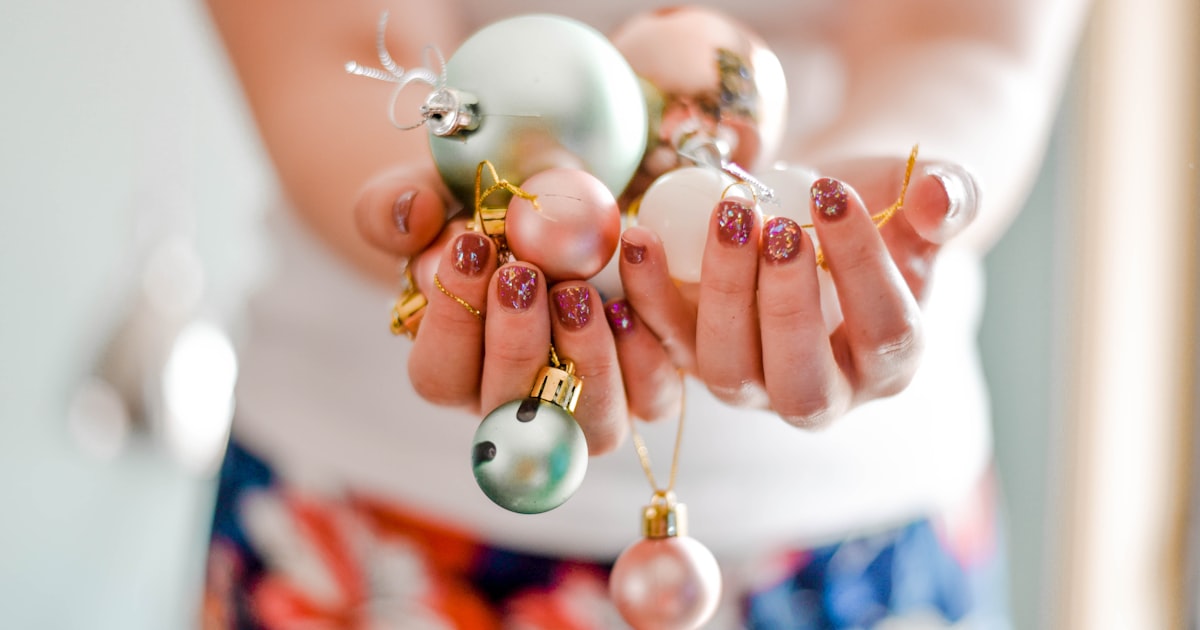Christmas nails 2026 shown holding decorative holiday baubles
